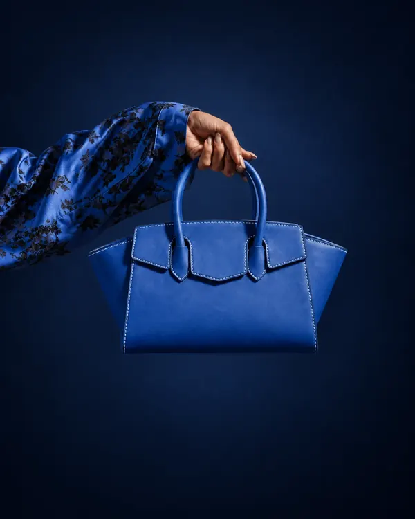Bag Believer azul segurada pela alça